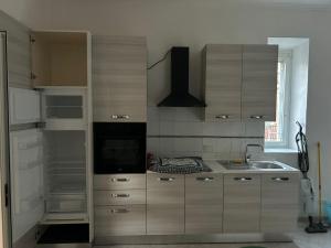 a kitchen with wooden cabinets and a sink at Alloggio Turistico Casa Mafalda in Rome