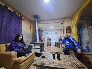 un hombre y una mujer sentados en una sala de estar en Hostal y Viajes Balmaceda 