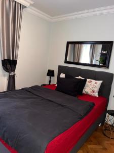 Schlafzimmer mit einem roten und schwarzen Bett und einem Fenster in der Unterkunft Apartment D-22 in Belgrad