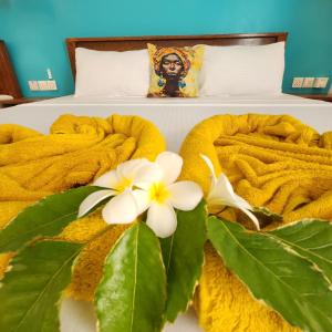 a bed with yellow towels and white flowers on it at Olzadia Boutique Hotel in Michamvi