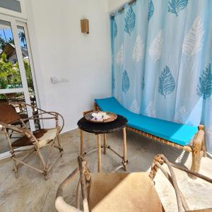 a room with a bench and a table and a chair at Olzadia Boutique Hotel in Michamvi