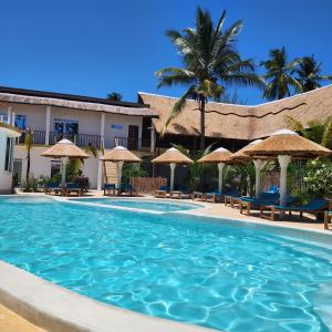 a swimming pool with umbrellas and a resort at Olzadia Boutique Hotel in Michamvi +7 photos