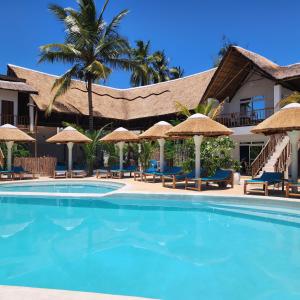a pool at the resort with chairs and umbrellas at Olzadia Boutique Hotel in Michamvi