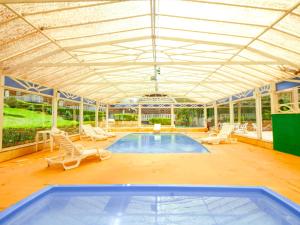 una gran piscina con sillas y techo en VELINN Áustria Hotel Monte Verde, en Monte Verde