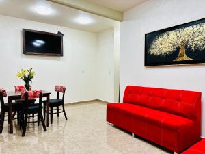 uma sala de estar com um sofá vermelho e uma mesa em HOTEL OTOMI em Otumba de Gómez Farías