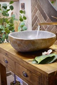 a stone bowl on top of a wooden table with a plant at BALI DREAM, pour une escapade inoubliable! in Grenoble