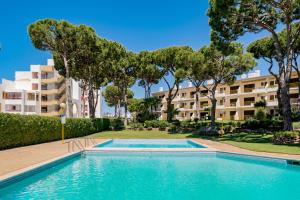 an empty swimming pool in front of a building at AL - Sol Nascente ll Apartamentos in Vilamoura
