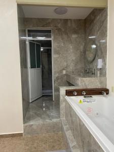 baño grande con bañera y lavamanos en HOTEL OTOMI en Otumba de Gómez Farías