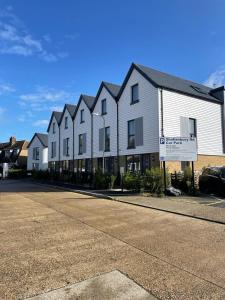 un gran edificio blanco con un cartel delante en Salt Yard Apartment, Parking and Terrace, Whitstable, en Whitstable