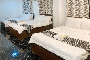 a room with three beds with white sheets at Stay Inn Station 2 Boracay by RedDoorz in Boracay