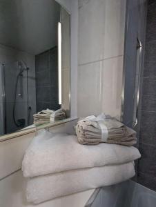 a bathroom with a mirror and towels on a tub at NEW Lux 1 or 2 Bed Flats + Car Park + 5min Tube + Fast WiFi in London