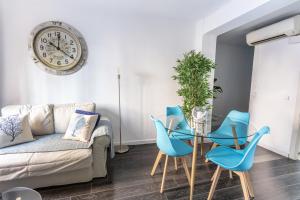 een woonkamer met blauwe stoelen en een klok aan de muur bij Sailor Apartment nel Cabanyal in Valencia
