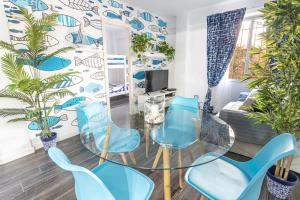 een woonkamer met een glazen tafel en blauwe stoelen bij Sailor Apartment nel Cabanyal in Valencia
