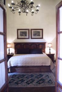a bedroom with a large bed with a chandelier at Casa Eugenia Hotel in Morelia