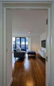 a living room with a couch and a table at NEW Lux 1 or 2 Bed Flats + Car Park + 5min Tube + Fast WiFi in London