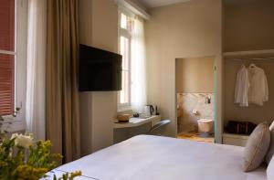 a bedroom with a bed and a bathroom at Vrachos Athens Suites in Athens