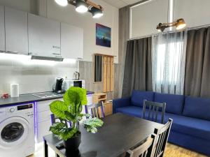 a kitchen and living room with a table and a blue couch at Grandera Apart`s - Lliri 32 in Valencia