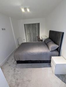 um quarto com uma cama num quarto em NEW Lux 1 or 2 Bed Flats + Car Park + 5min Tube + Fast WiFi em Londres