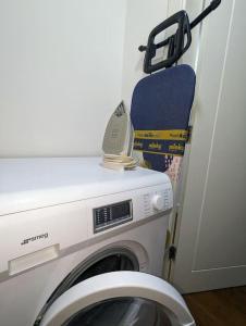 uma máquina de lavar roupa num quarto ao lado de uma porta em NEW Lux 1 or 2 Bed Flats + Car Park + 5min Tube + Fast WiFi em Londres