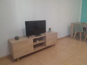 un centro di intrattenimento in legno con TV a schermo piatto di Casa Damar a Corralejo