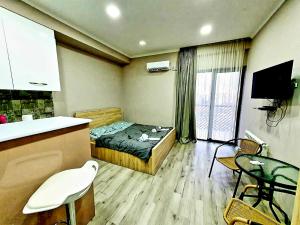 een slaapkamer met een bed en een keuken met een tafel bij The nice cozy flat in tbilisi in Tbilisi City