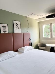 - une chambre avec un lit blanc et une fenêtre dans l'établissement ibis Nîmes Ouest - A9, à Nîmes