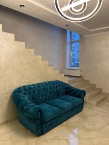 a blue couch in a living room with stairs at Holiday house in Vinnytsya