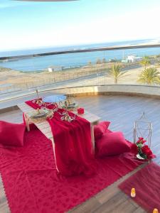 a table with a red table cloth on a red rug at RESIDENCE PUERTO MARINA Corniche d'Asilah in Asilah