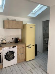 a kitchen with a yellow refrigerator and a washing machine at LE CABANON DE MARIUS in Six-Fours-les-Plages