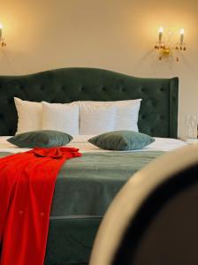 a bedroom with a large bed with a green headboard at 4Cardinal's Hotel Boutique in Braşov