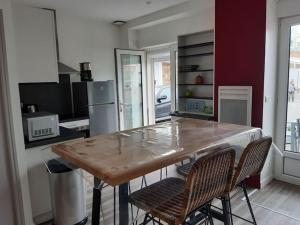 eine Küche mit einem Holztisch und 2 Stühlen in der Unterkunft Petite maison proche plage 2/4 p in La Bernerie-en-Retz