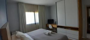 een slaapkamer met een bed, een bureau en een raam bij Cantal Bed & Breakfast in El Durazno