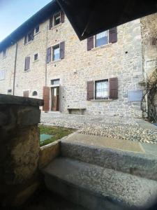 - un bâtiment en pierre avec un escalier devant dans l'établissement La piccola Corte, à Roncola