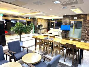 a dining room with tables and chairs and a television at HOTEL airport June in Incheon