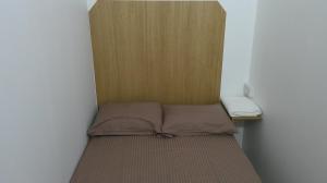um pequeno quarto com uma cama e uma parede de madeira em Ruby Star Hostel 21 Dubai no Dubai