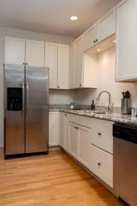 a kitchen with white cabinets and a stainless steel refrigerator at Flexhome Wicker Park 2BR P1 - READ INFO in Chicago