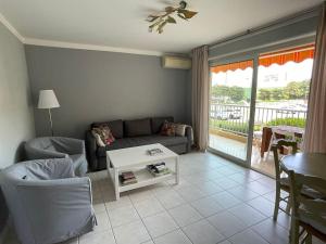 a living room with a couch and a table at Nice family apartment close to the beach in Le Lavandou
