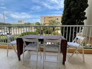 a wooden table and four chairs on a balcony at Nice family apartment close to the beach in Le Lavandou