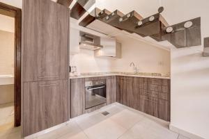 a kitchen with wooden cabinets and a sink at Al Riyahi Cabanas in Al Burj