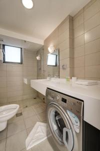 a washing machine in a bathroom with a sink at Al Riyahi Cabanas in Al Burj