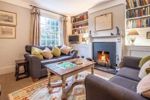 a living room with a couch and a fireplace at Mole Cottage, Orford in Woodbridge