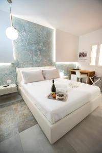 a large white bed with a bottle of wine on it at Guest House Azzurra in Lampedusa