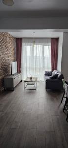 ein Wohnzimmer mit einem Sofa und einem Couchtisch in der Unterkunft Apartament lângă VIVO in Floreşti