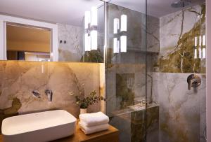 a bathroom with a sink and a shower at Vrachos Athens Suites in Athens +57 photos
