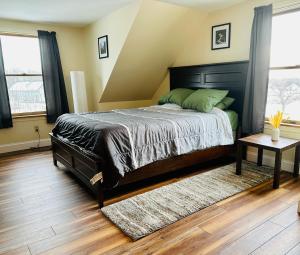 a bedroom with a large bed and a wooden floor at Spacious Country Home, Hot Tub, Fire Pit, Deck 