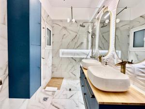 a bathroom with two sinks and a mirror at Elaia Luxury Selections Sapphire in Athens