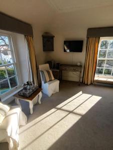 een woonkamer met een bank en een tv bij The Mount in Bideford