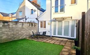 a white house with a lawn in front of it at Victoria House by Switchback Stays in Cardiff