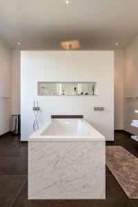 a large white bath tub in a room at Bohemian Residence in Maastricht +8 photos