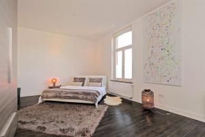 a white room with a bed and a window at Bohemian Residence in Maastricht